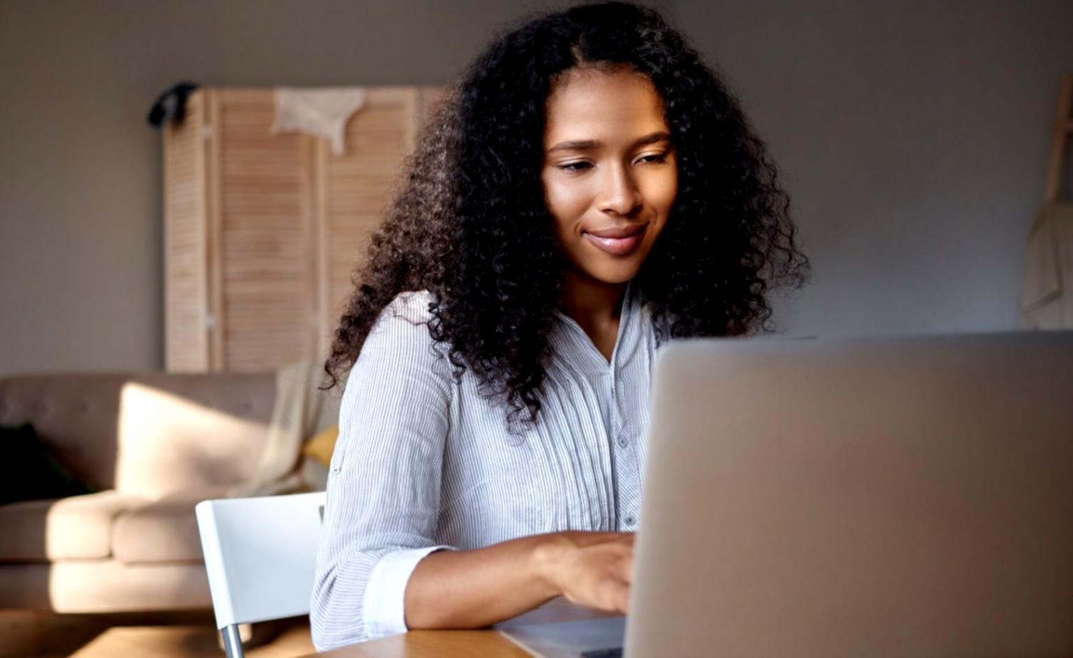 Person plant Finanzen am Laptop mit Dokumenten